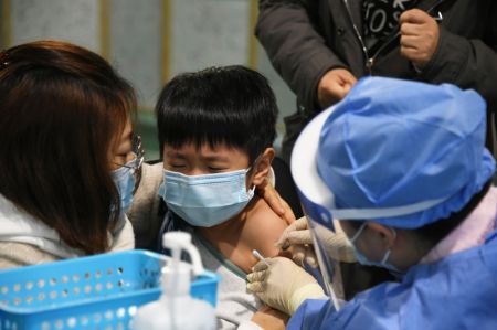 (miniature) Un enfant reçoit une dose de vaccin contre la COVID-19 dans un site de vaccination dans l'arrondissement de Haidian à Beijing