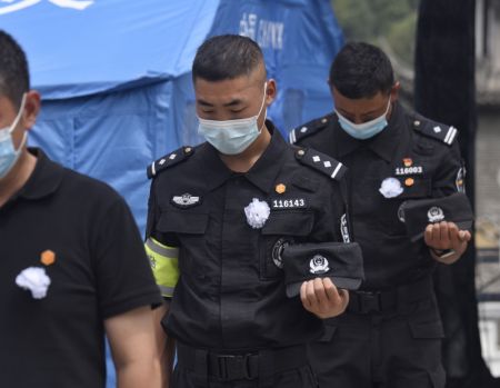 (miniature) Des policiers rendent hommage aux victimes du séisme lors d'un service commémoratif dans le district de Luding