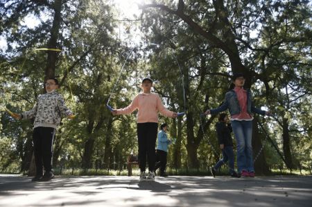 (miniature) Des enfants jouent à la corde à sauter dans le parc du Temple du Ciel pendant les congés de la Fête nationale et de la Fête de la mi-automne