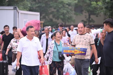 (miniature) Des villageois prennent leurs effets personnels et se préparent à rentrer chez eux depuis un site de relogement de l'arrondissement de Xiqing