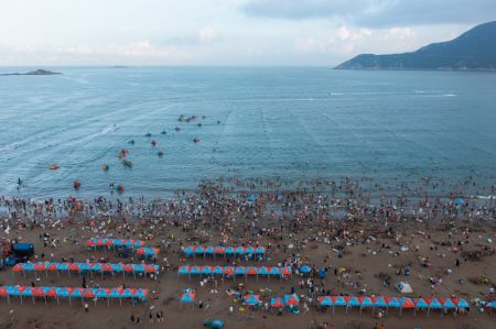 (miniature) Photo aérienne de touristes s'amusant au bord de la mer