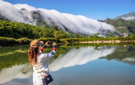 (miniature) Une touriste prend photos des nuages dévalant du mont Jinfo à Chongqing