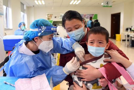 (miniature) Un enfant reçoit une dose de vaccin contre la COVID-19 dans un site de vaccination dans l'arrondissement de Haidian à Beijing