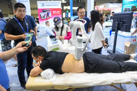 (miniature) Un visiteur fait l'expérience d'un massage par un robot lors de la 26e Foire des hautes technologies de Chine à Shenzhen