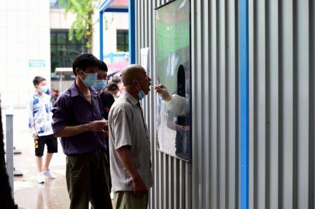 (miniature) Un membre du personnel médical prélève un échantillon de gorge sur un habitant pour des tests d'acide nucléique dans un hôpital dans le district de Feixi