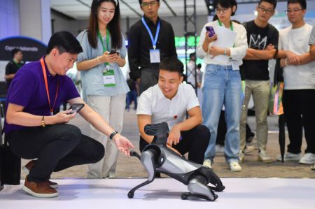 (miniature) Des visiteurs interagissent avec un chien robot lors de la Conférence mondiale sur l'informatique 2023 à Changsha