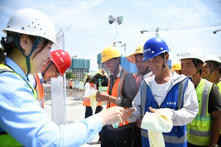 (miniature) Une employée distribue des produits de prévention de la chaleur aux ouvriers sur un chantier à Xi'an