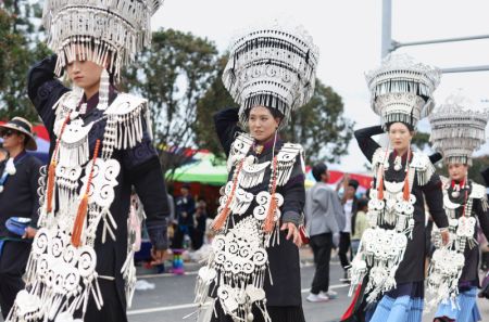 (miniature) Des habitants locaux vêtus de costumes traditionnels de l'ethnie Yi marchent dans une rue