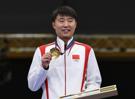 (miniature) Le médaillé d'or chinois Li Yuehong assiste à la cérémonie de remise des prix après la finale masculine du Tir au pistolet à 25 m tir rapide aux Jeux olympiques de Paris 2024 à Châteauroux