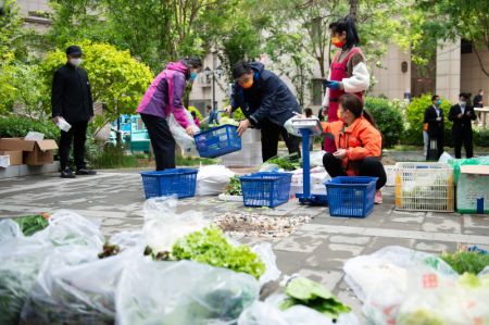 (miniature) Un habitant achète des légumes devant un point de vente de produits de première nécessité dans un quartier résidentiel de l'arrondissement de Chaoyang