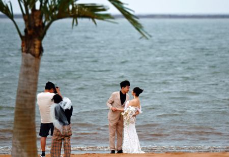 (miniature) Un couple pose pour des photos au bord de la mer dans la Nouvelle Zone de Binhai