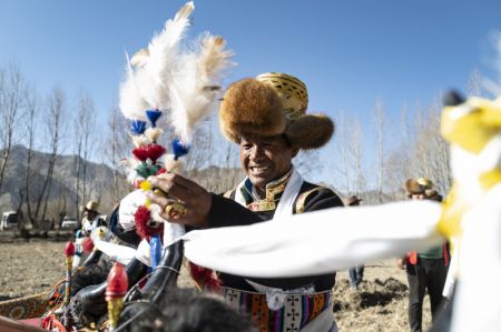 (miniature) Un villageois arrange la décoration d'un tracteur lors d'une cérémonie marquant le début du labour printanier dans le village de Carbanang