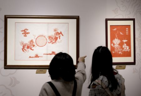 (miniature) Des visiteuses contemplent des oeuvres présentées à une exposition sur le patrimoine culturel immatériel de la Route de la soie maritime