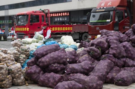 (miniature) Des bénévoles transportent des produits de première nécessité pour les distribuer aux habitants de l'arrondissement de Shangyu de la ville de Shaoxing