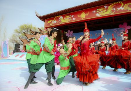 (miniature) Des danseurs donnent un spectacle lors de la cérémonie d'ouverture d'un festival des fleurs d'abricotiers dans le district de Toksun
