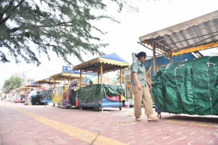 (miniature) Une employée vérifie les étals à Beihai