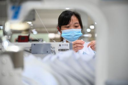 (miniature) Une employ&eacute;e travaille sur une ligne de production d'une entreprise de chaussures de sport