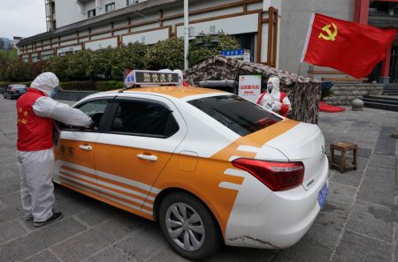 (miniature) Un chauffeur de taxi scanne son code de santé à un point de contrôle de l'épidémie dans un quartier de Wuhan