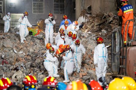 (miniature) Des secouristes transportent le dixième survivant de l'effondrement d'un bâtiment résidentiel