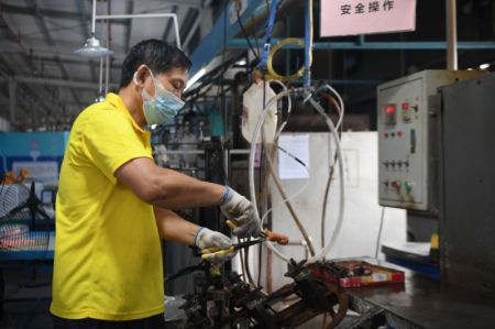 (miniature) Un employé fabrique des jouets dans une usine de produits en plastique à Zhangjiajie