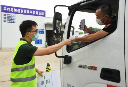(miniature) Un membre du personnel contr&ocirc;le la temp&eacute;rature corporelle d'un chauffeur de camion