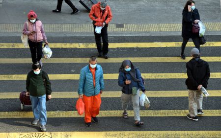 (miniature) Des personnes portant des masques traversent la rue à Hong Kong