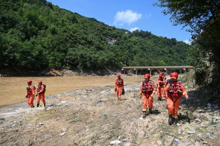 (miniature) Des sauveteurs travaillent sur le cours inférieur de la rivière près du site de l'effondrement d'un pont dans le district de Zhashui