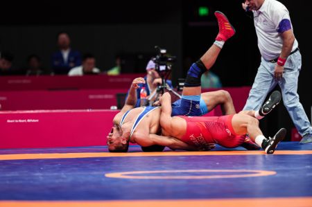 (miniature) Le Mongol Tulga Tumur-Ochir (bas) rivalise avec l'Iranien Rahman Amouzadkhalili lors du match pour les médailles des 65 kg de lutte libre masculine aux 19es Jeux asiatiques à Hangzhou