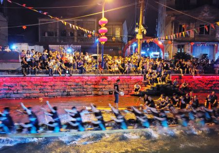 (miniature) Des personnes participent à une course de bateaux-dragons nocturne à l'occasion de la fête traditionnelle des bateaux-dragons à venir dans le village de Sanxi
