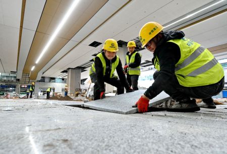 (miniature) Des ouvriers posent des carreaux de sol &agrave; la gare du Sud de Fuzhou &agrave; Fuzhou