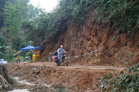 (miniature) Un motocycliste volontaire aide à transporter des fournitures de secours vers le site du récent crash aérien