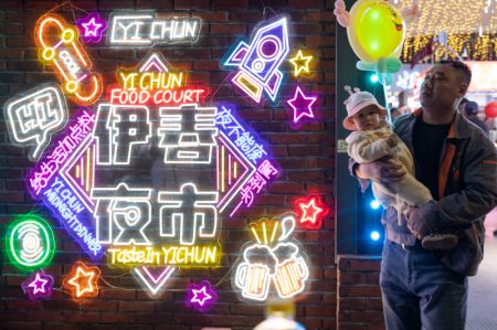 (miniature) Un homme avec un enfant dans ses bras dans un march&eacute; de nuit &agrave; Yichun