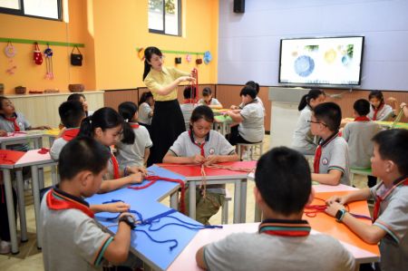 (miniature) Zhao Xun présente des techniques de tricotage à ses élèves au club de tricotage de l'Ecole primaire Luogang