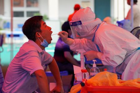 (miniature) Un professionnel de la santé prélève un échantillon par écouvillon sur un habitant dans un site de test d'acide nucléique de la COVID-19 de l'arrondissement de Guangling