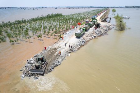 (miniature) Photo aérienne prise par un drone montrant des sauveteurs travaillant à colmater la brèche de la digue du lac Dongting à Huarong