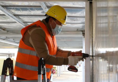 (miniature) Un ouvrier installe une porte sur le site de construction d'un centre d'isolement à Shijiazhuang