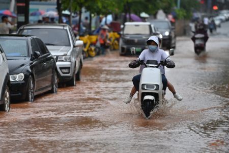 (miniature) Des habitants en scooter dans une rue inondée de Nanning