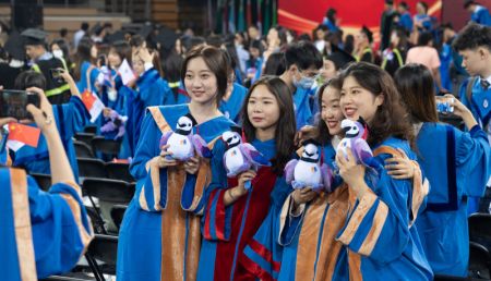 (miniature) Des diplômés prennent des photos de groupe lors d'une cérémonie de remise des diplômes à l'Université des langues étrangères de Beijing (BFSU)