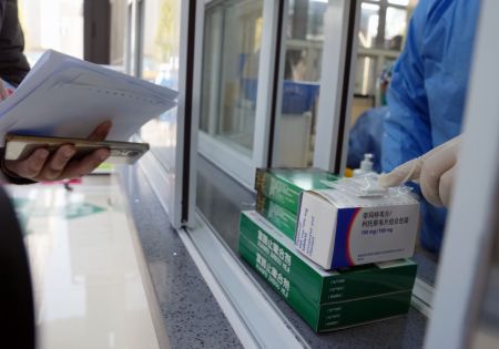(miniature) Un pharmacien distribue des médicaments à des proches de patients dans la clinique spécialisée dans le traitement de la fièvre d'un établissement de santé communautaire à Shanghai