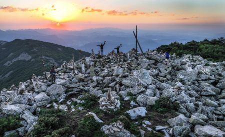 (miniature) Des touristes contemplent le lever du soleil au sommet de la montagne Caolianling dans le district de Luonan de la ville de Shangluo