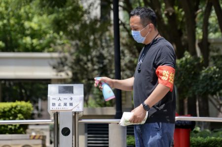 (miniature) Un travailleur communautaire désinfecte l'entrée d'une communauté résidentielle à Jiugong