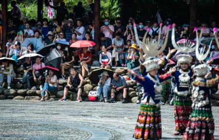 (miniature) Des touristes regardent un spectacle de danse traditionnelle dans le village Miao de Xijiang Qianhu