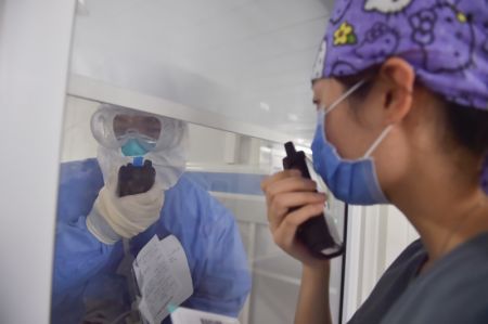 (miniature) Une infirmière (à gauche) venue en renfort apprend à utiliser l'interphone avec l'aide de son collègue à l'hôpital de Ditan à Beijing