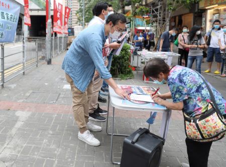 (miniature) Des citoyens signent lors d'une campagne de rue en faveur de la législation sur la sécurité nationale pour la Région administrative spéciale (RAS) de Hong Kong à Hong Kong