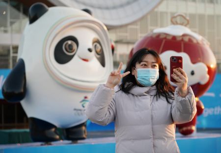 (miniature) Une visiteuse prend des photos devant des décorations sur le thème des Jeux olympiques d'hiver de Beijing 2022 dans l'arrondissement de Yanqing