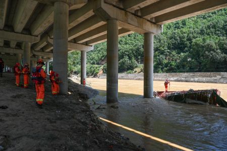 (miniature) Des secouristes travaillent sur le cours inférieur de la rivière près du site de l'effondrement d'un pont dans le district de Zhashui de la ville de Shangluo