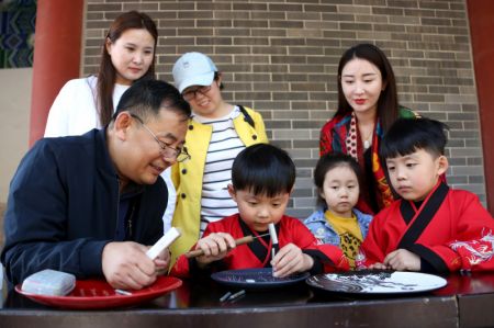 (miniature) Des enfants apprennent la technique de la sculpture sur porcelaine dans le bourg de Mengzhuang de la ville de Zaozhuang