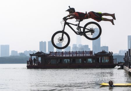 (miniature) Un cycliste saute dans le lac de l'Est lors d'un festival annuel de saut en BMX à Wuhan