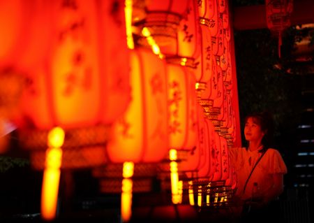 (miniature) Une visiteuse admire les installations lumineuses de la fête de la mi-automne au site touristique du pavillon Tengwang