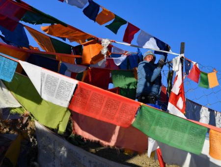 (miniature) Un homme accroche des drapeaux de prières sur une montagne à Xigaze